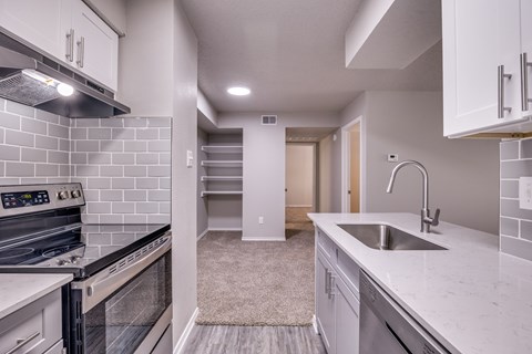 A modern kitchen with a stove top oven and a sink.