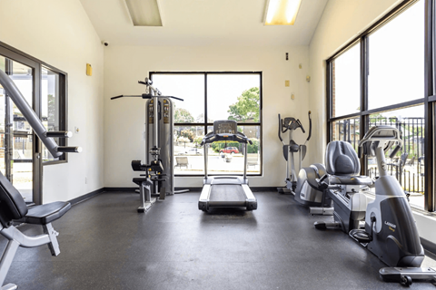 A spacious gym with a variety of equipment including treadmills, weights, and exercise machines.
