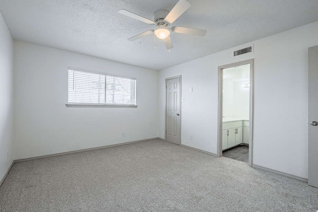 the living room of an empty house with a ceiling fan