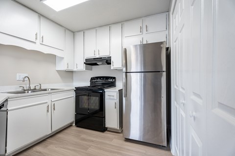 A kitchen with white cabinets and a black oven.