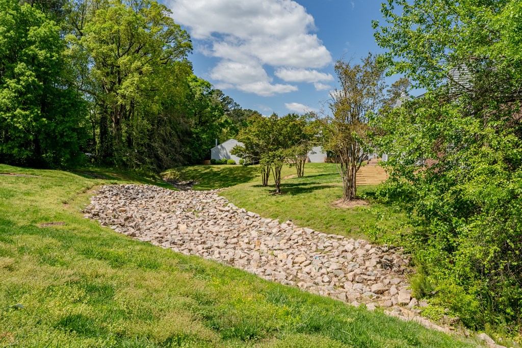 A stone pathway leads through a grassy area. A stone pathway leads through a grassy area. at Rosen at North Hills, Raleigh