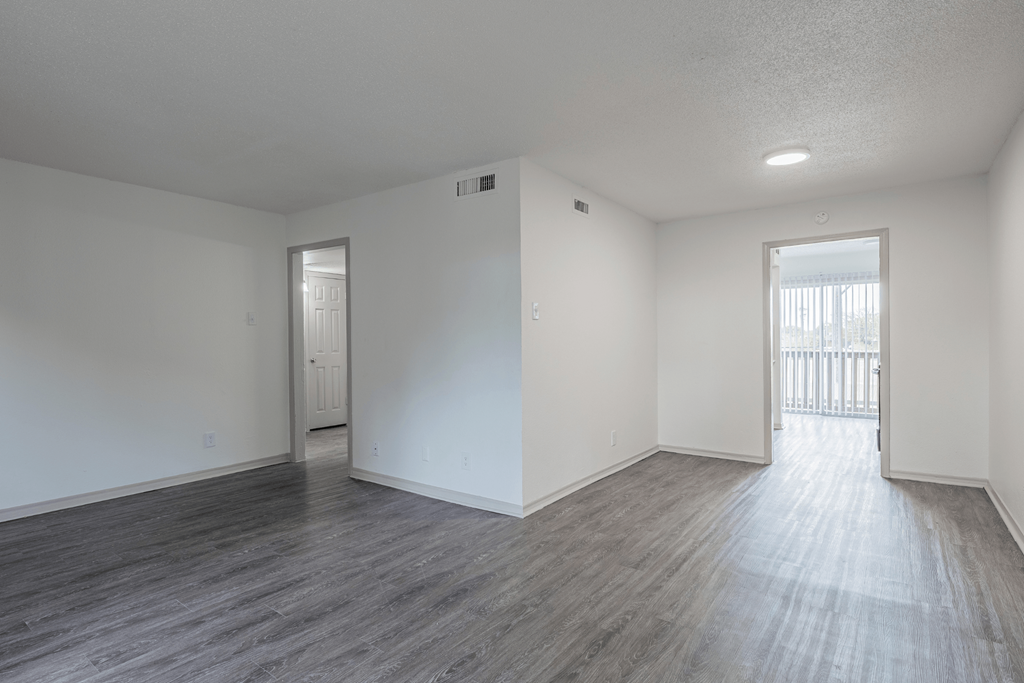 an empty living room with white walls and wood flooring