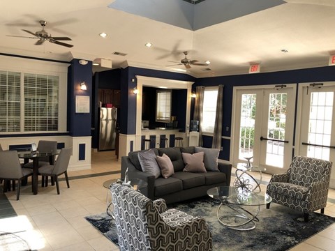 A living room with a grey couch and a glass coffee table.