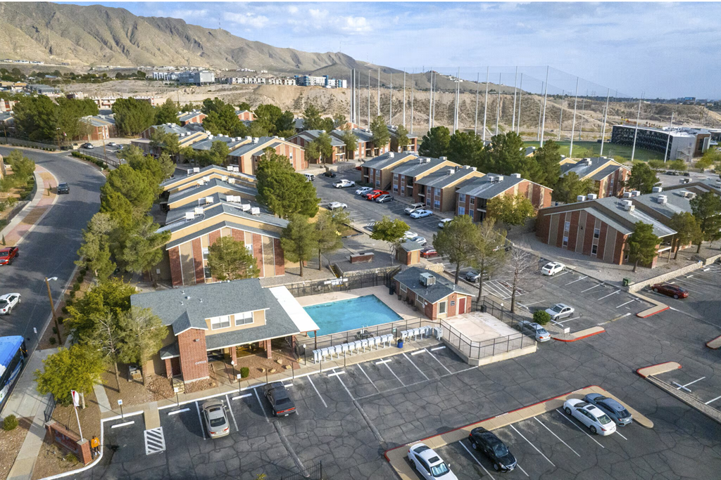 A parking lot with a building and a pool.
