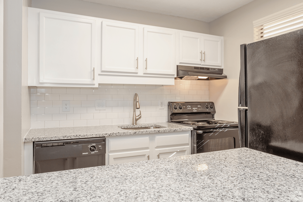 a kitchen with white cabinets and stainless steel appliances at The Hudson, North Carolina