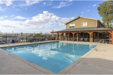 A large outdoor swimming pool with a building in the background.