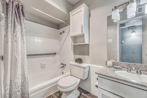 A white bathroom with a toilet, sink, and shower.