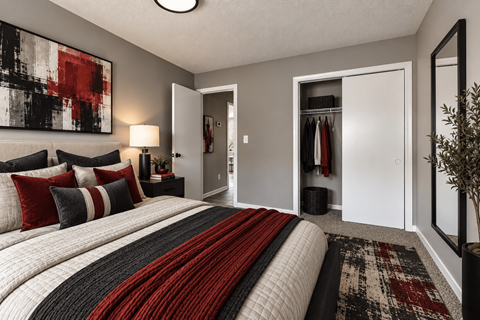 A bedroom with a large bed and a painting on the wall.