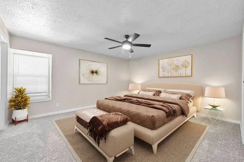 A bedroom with a large bed and a ceiling fan.