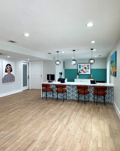 A kitchen with a bar stool and a painting on the wall.
