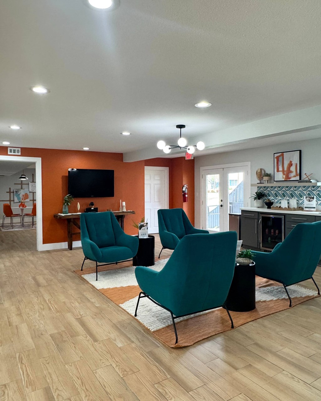 A living room with a television, chairs, and a fireplace at Carisma in Richardson, TX