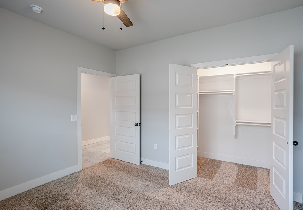 A room with two white doors and a carpeted floor at Cedar Crest Apartments, Farmington, AR, 72730