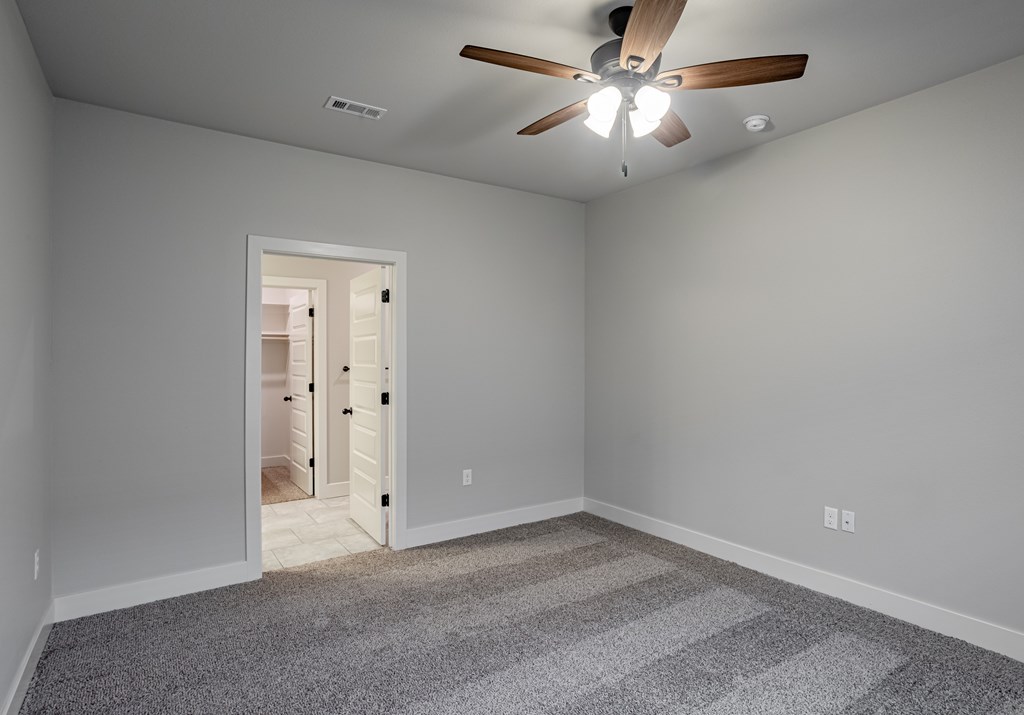 A room with a ceiling fan and a carpeted floor at Cedar Crest Apartments, Farmington, Arkansas