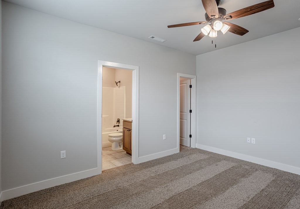 A room with a ceiling fan and a carpeted floor at Cedar Crest Apartments, Farmington, AR