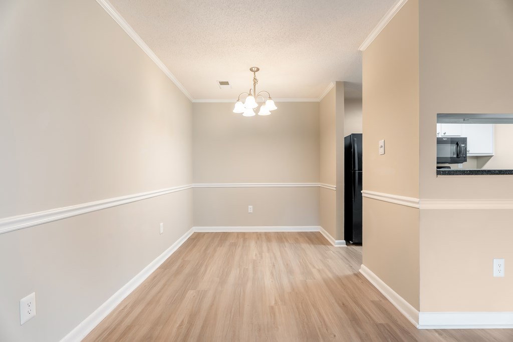 A room with wooden floors and a chandelier. at Rosewood at Colony Square, Rocky Mount