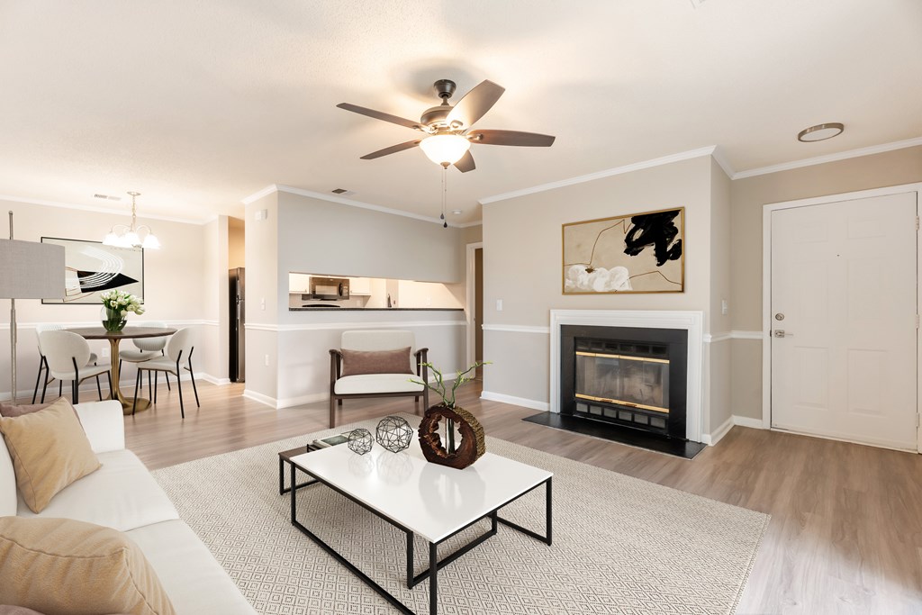 A living room with a fireplace and a white couch. at Rosewood at Colony Square, Rocky Mount