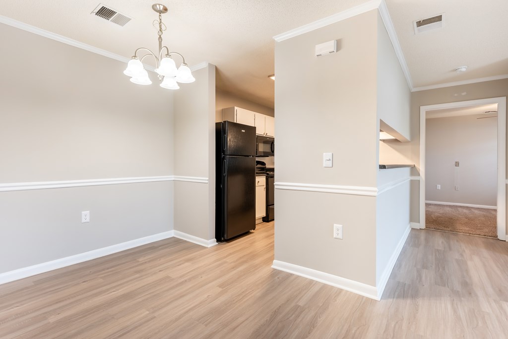 A kitchen area with a black fridge and wooden flooring. at Rosewood at Colony Square, Rocky Mount, NC