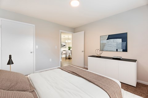 A bedroom with a large bed and a painting on the wall.