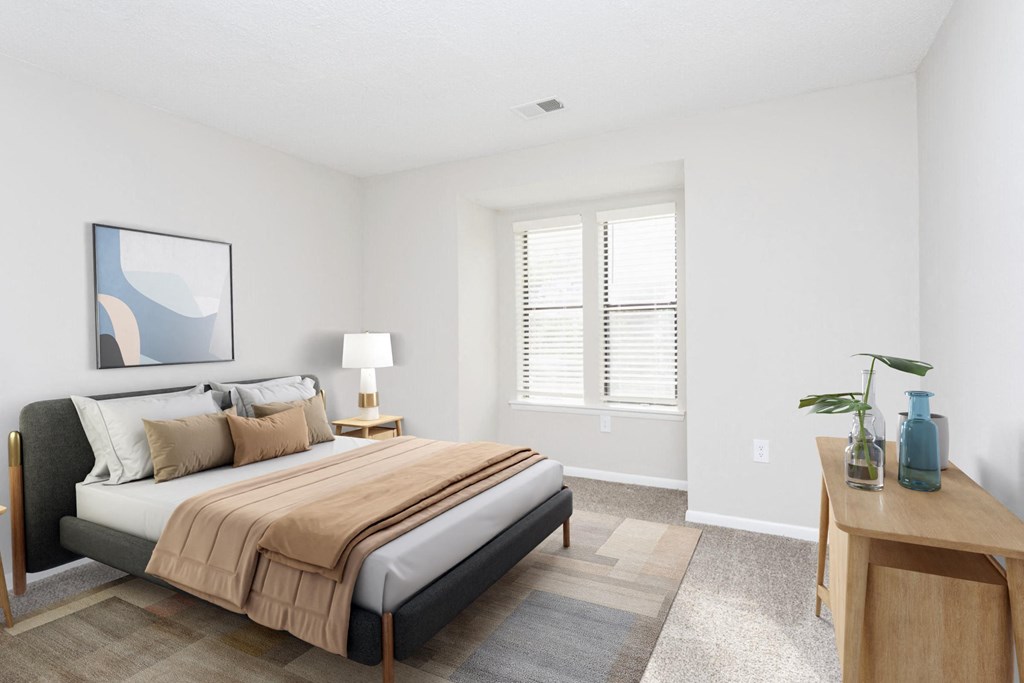 a bedroom with a bed and a desk with a window