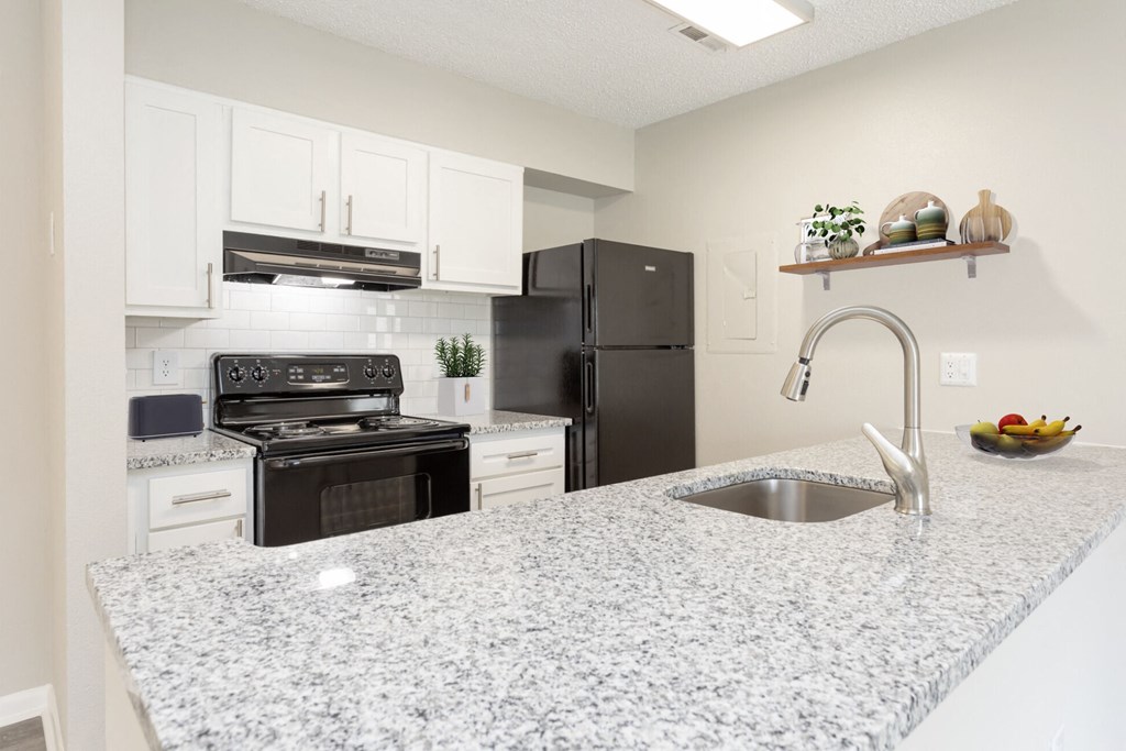 a kitchen with granite counter tops and black appliances