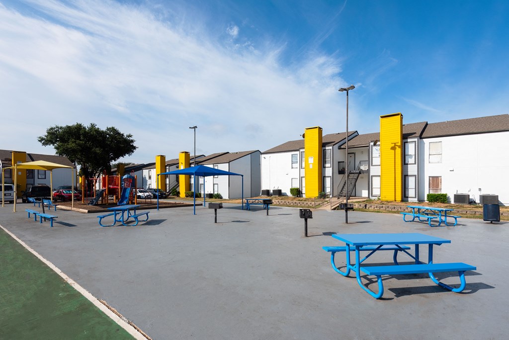 an empty playground with picnic tables and playground equipment at an elementary school an empty playground with picnic tables and playground equipment at an elementary school at Helios, Dallas, TX