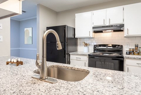 a kitchen with granite counter tops and black appliances