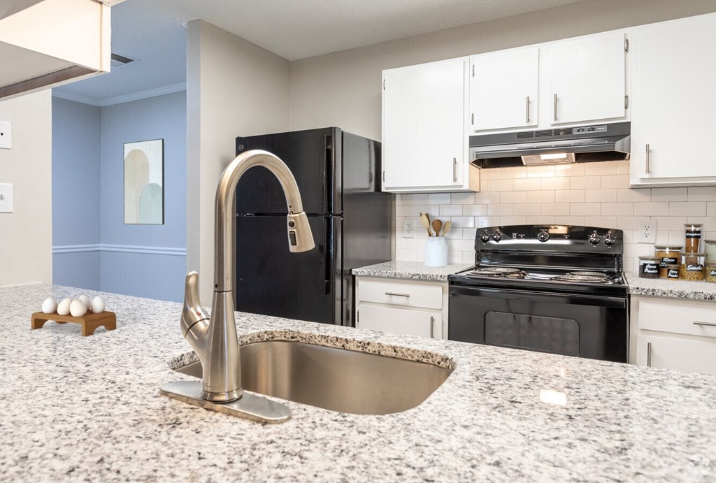 a kitchen with granite counter tops and black appliances