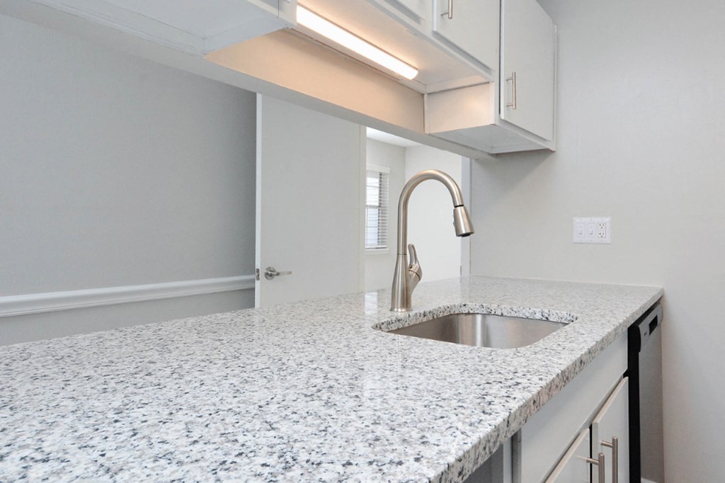 an empty kitchen with granite counter tops and a sink  at Henley, Fayetteville, NC, 28311