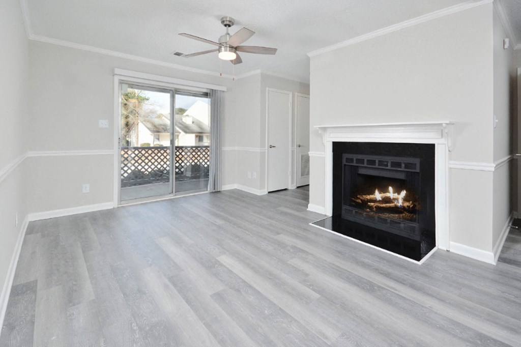 living room with faux wood flooring and a fireplace with a window to a patio and a ceiling fan  at Henley, North Carolina, 28311