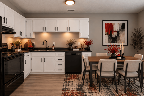 A modern kitchen with white cabinets and a black countertop.