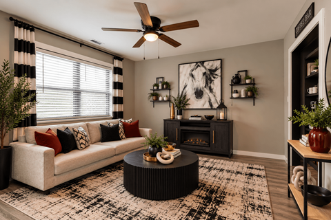 A living room with a white couch, a black coffee table, and a ceiling fan.
