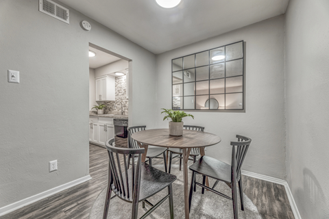 A dining room with a round table and chairs.