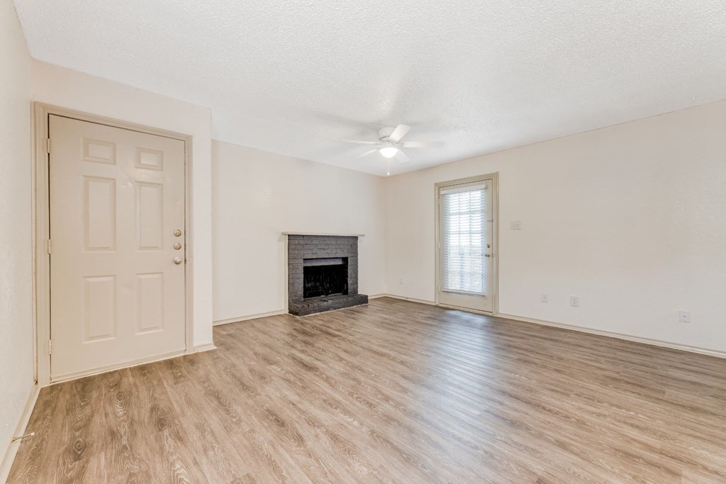 an empty living room with a fireplace and a door