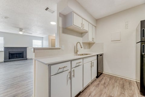 a white kitchen with white cabinets and a stainless steel refrigerator