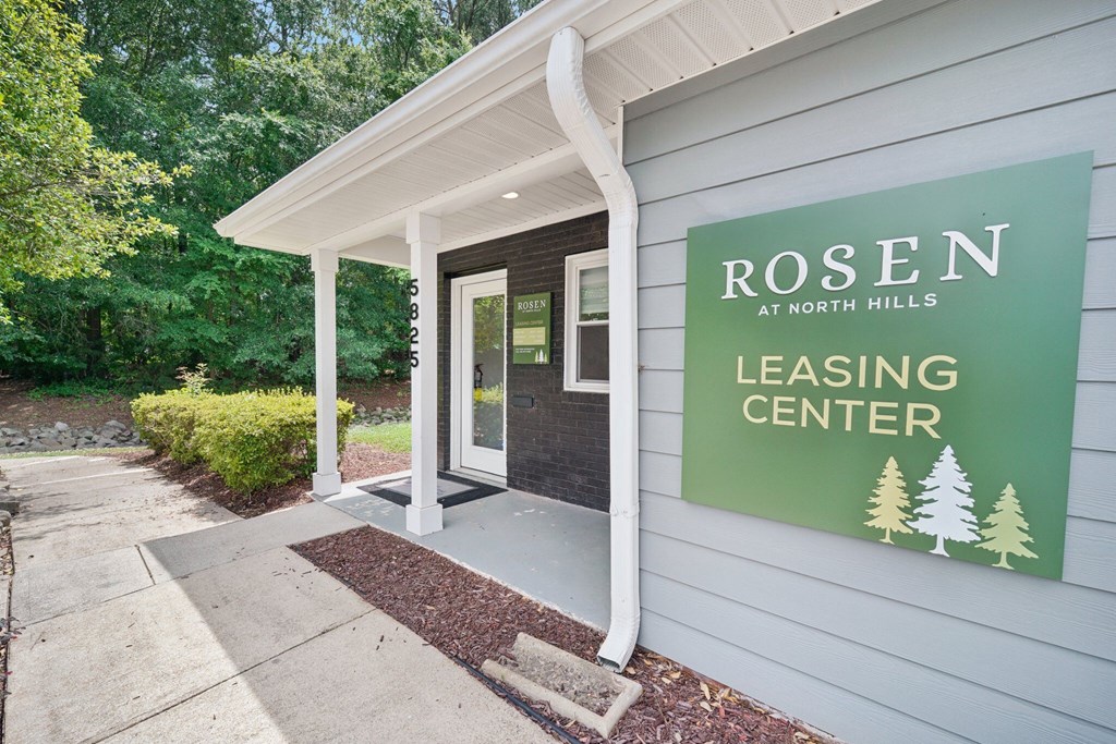 the entrance to rosemary hills leasing center with a green sign on the building