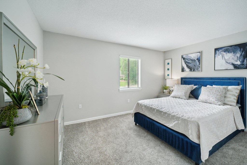 a bedroom with a bed and a dresser and a window