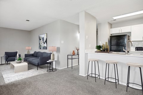 an open living room and kitchen with a bar and a couch