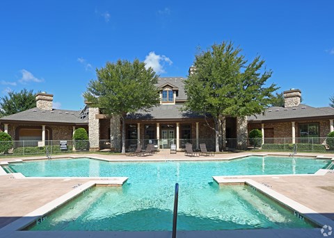A large house with a pool in front.