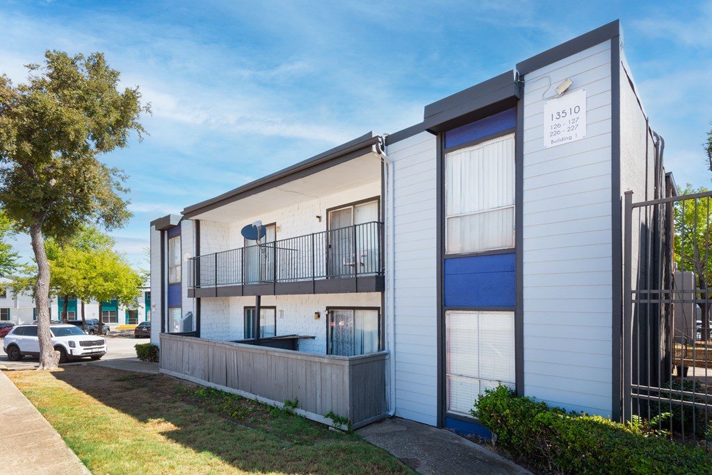 a white building with blue windows and a sidewalk at Lumina, Dallas, TX