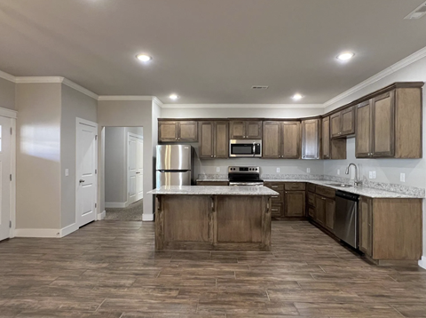 A kitchen with wooden cabinets and a central island at Cedar Crest Apartments, Arkansas