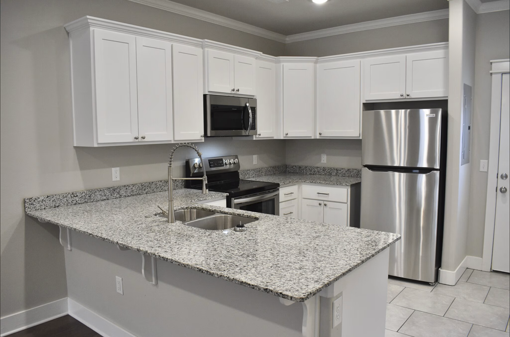 A kitchen with granite countertops and stainless steel appliances at Cedar Crest Apartments, Arkansas, 72730