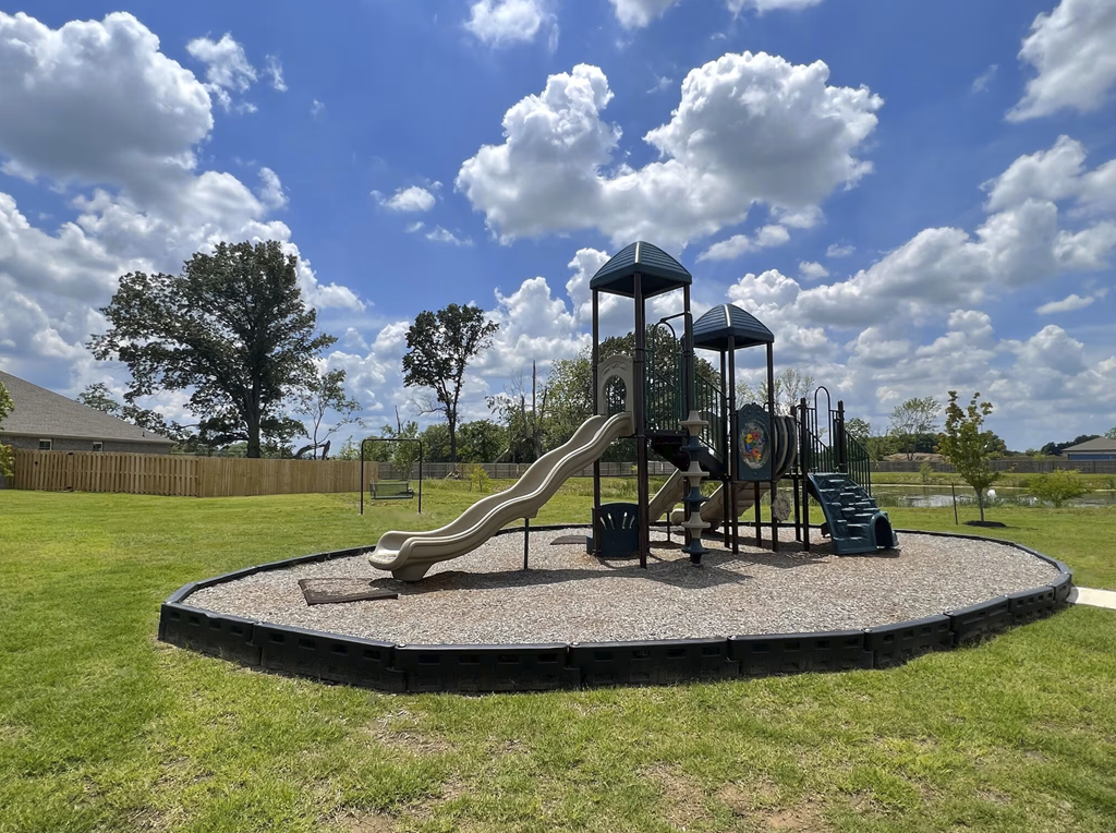 A playground with a slide and a green tower at Cedar Crest Apartments, Farmington 72730