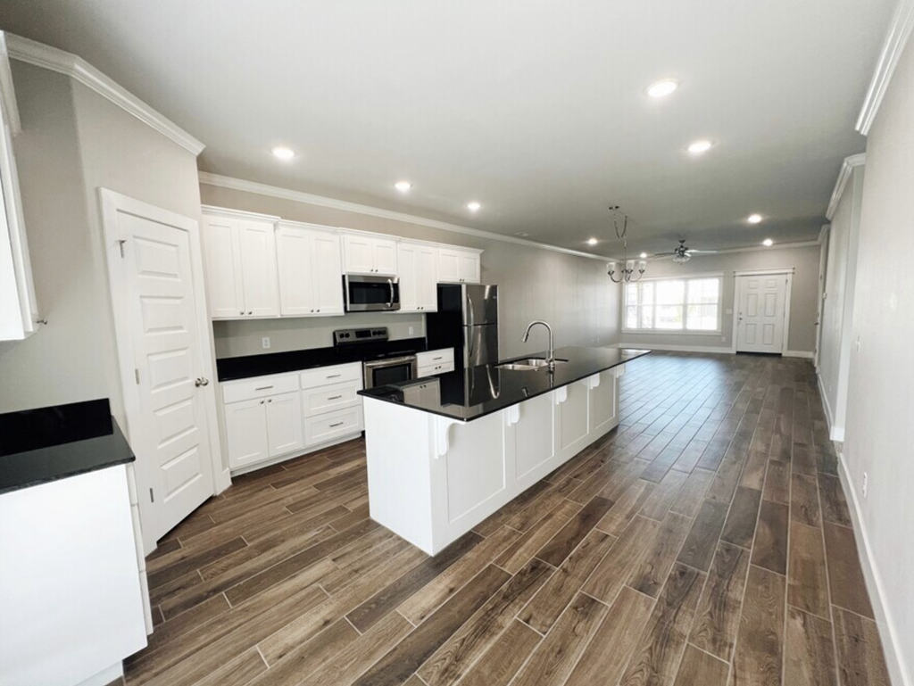 A kitchen with white cabinets and a black countertop at Cedar Crest Apartments, Farmington