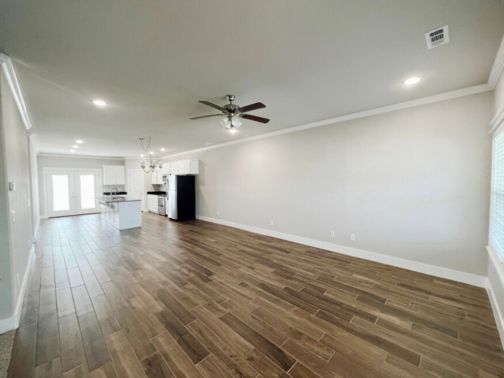 A room with a ceiling fan and wooden flooring at Cedar Crest Apartments, Arkansas, 72730