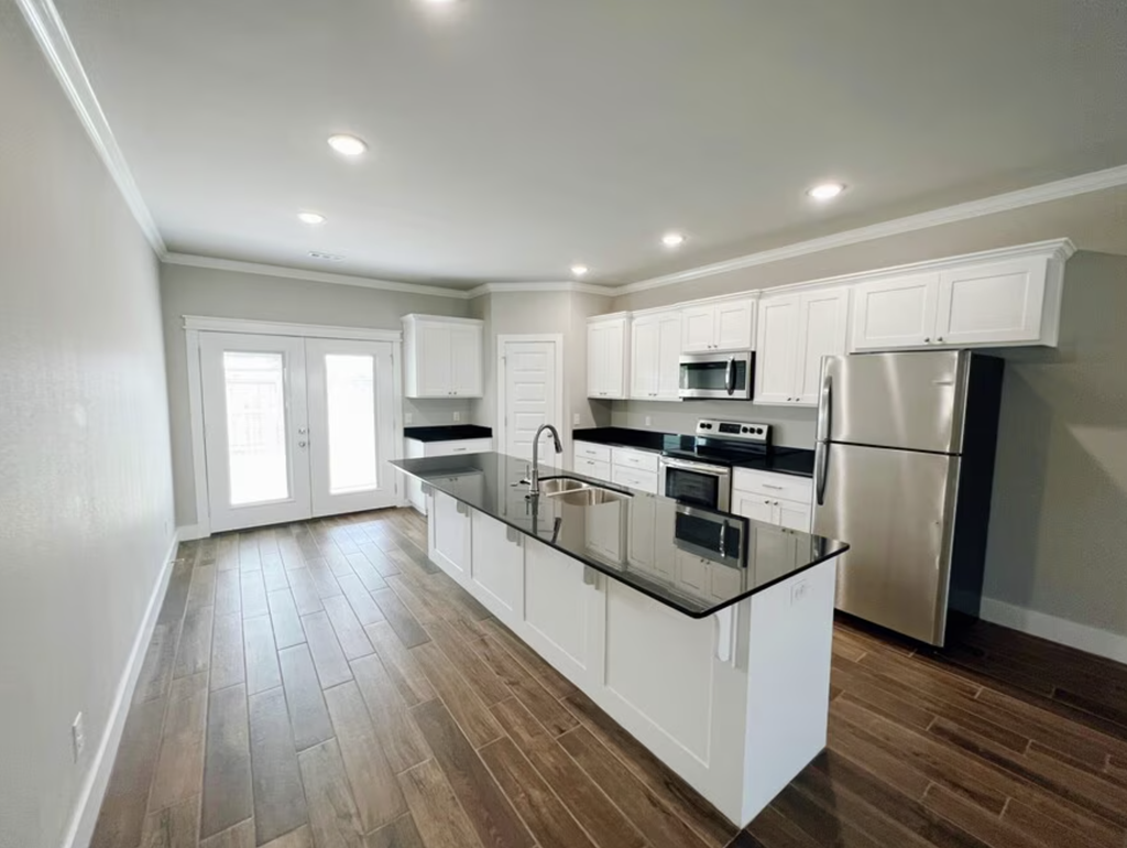 A modern kitchen with white cabinets and a wooden floor. at Cedar Crest Apartments, Farmington, AR, 72730