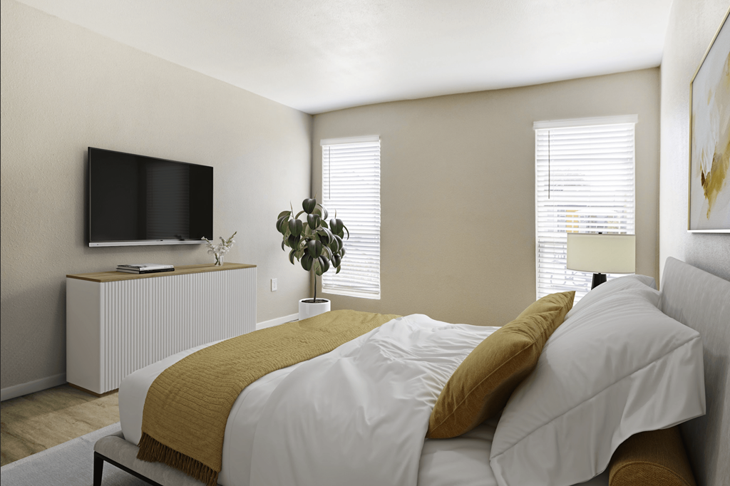 A bedroom with a bed, a television, and a plant.