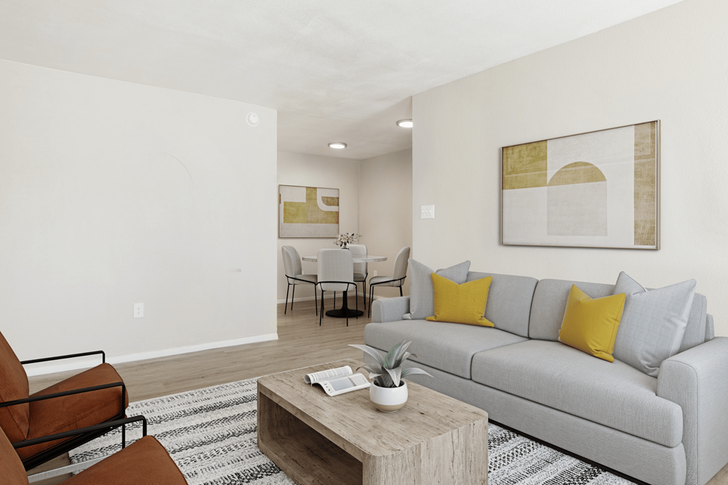 A living room with a grey couch, a coffee table, and a painting on the wall.