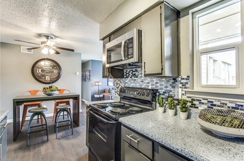A kitchen with a black stove top oven and a black and white checkered back splash.