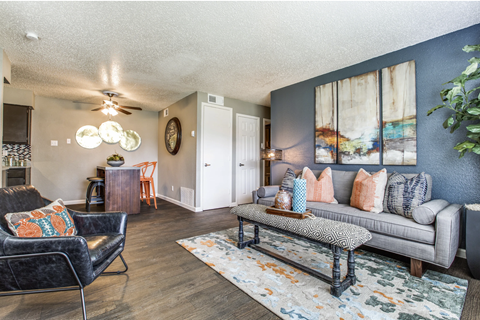 A living room with a black chair and a grey couch.