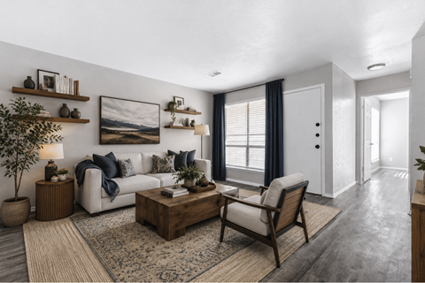 A living room with a white couch, a wooden coffee table, and a large painting on the wall.